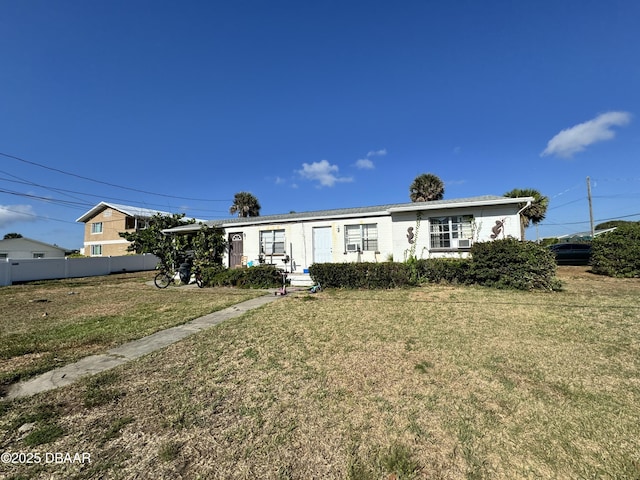 view of front of house with a front yard and fence