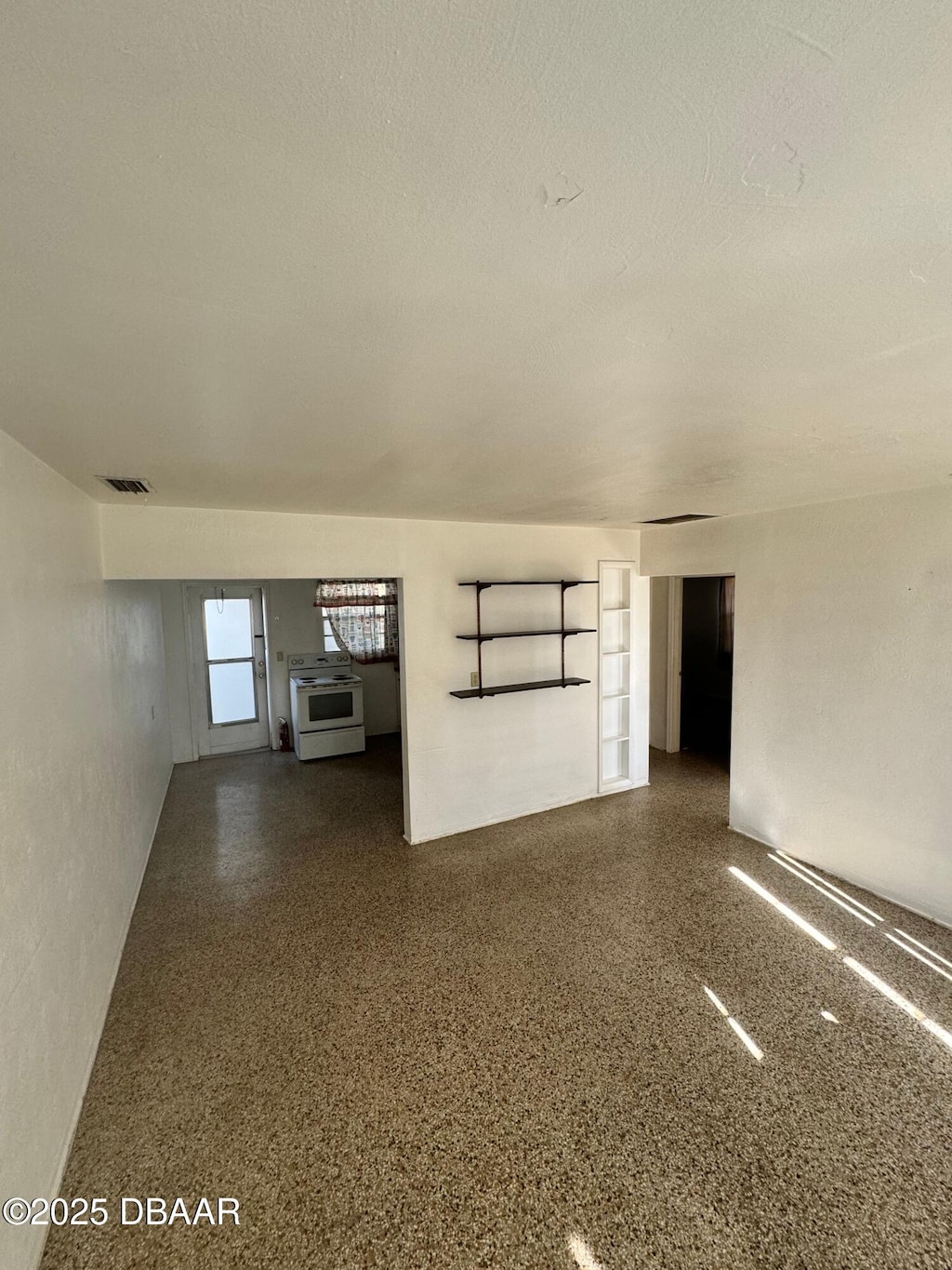 unfurnished room with visible vents, speckled floor, and a textured ceiling