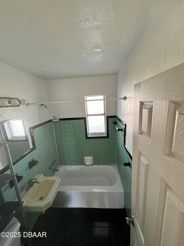 bathroom with a sink, tile walls, shower / bathtub combination, and tile patterned flooring