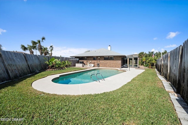 view of swimming pool with a bar, a yard, and a patio