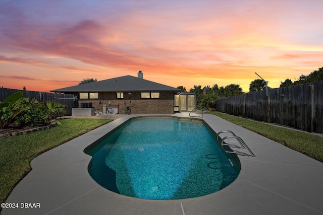 pool at dusk with a patio