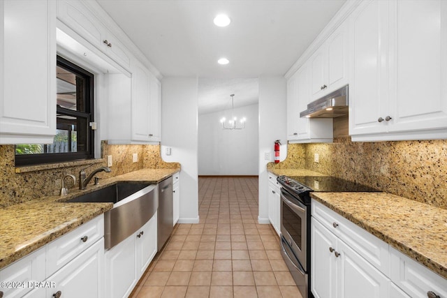 kitchen featuring white cabinetry, light stone countertops, decorative light fixtures, and appliances with stainless steel finishes