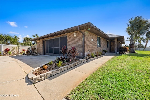 ranch-style house with a garage and a front lawn