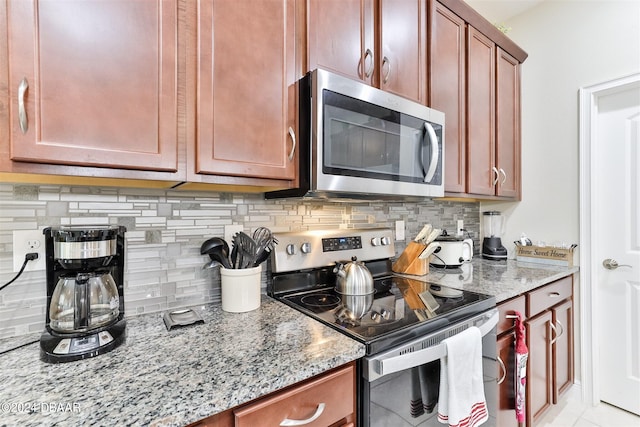 kitchen featuring decorative backsplash, light stone counters, and stainless steel appliances