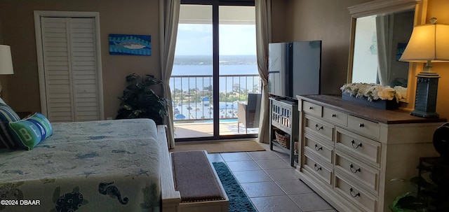 bedroom with access to exterior, light tile patterned floors, and multiple windows