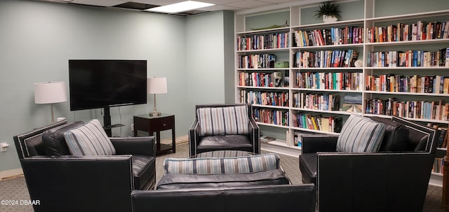 living area with a paneled ceiling