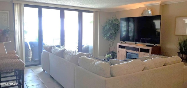 living area featuring light tile patterned floors, a glass covered fireplace, and a textured ceiling