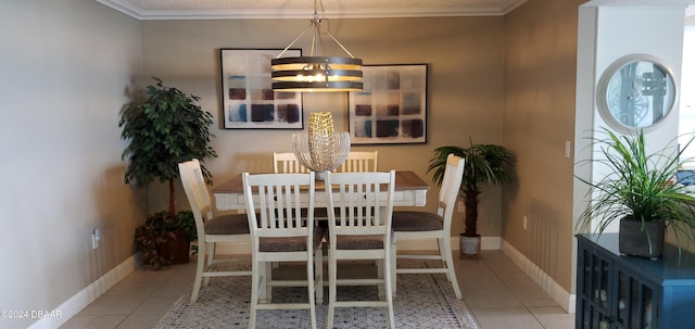 tiled dining room featuring crown molding and a chandelier