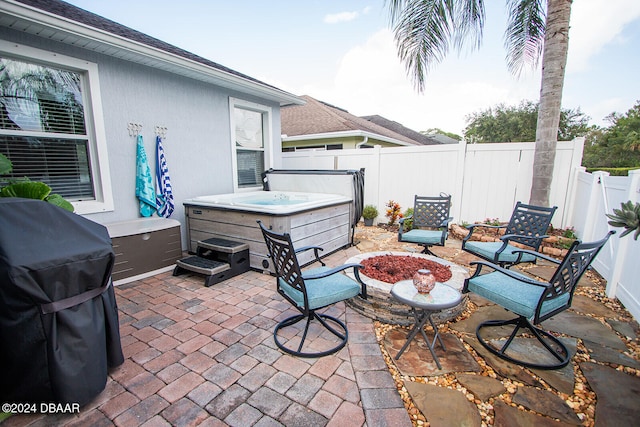 view of patio featuring a fenced backyard, a grill, and a hot tub