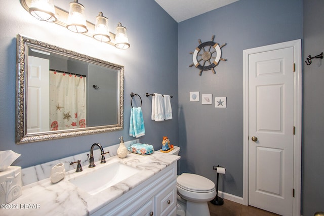 bathroom with baseboards, a shower with shower curtain, toilet, tile patterned flooring, and vanity