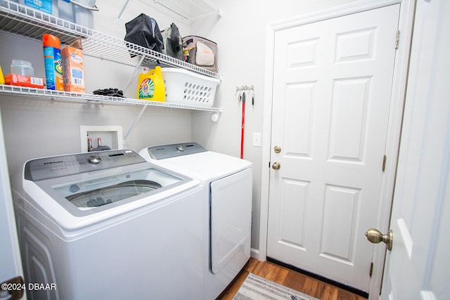 clothes washing area featuring wood-type flooring and independent washer and dryer