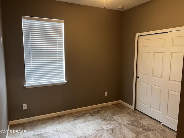 unfurnished bedroom featuring a closet and baseboards