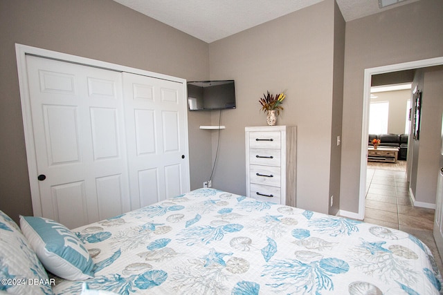 tiled bedroom with a closet and a textured ceiling