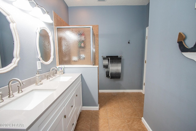 bathroom featuring a sink, a shower stall, baseboards, and double vanity