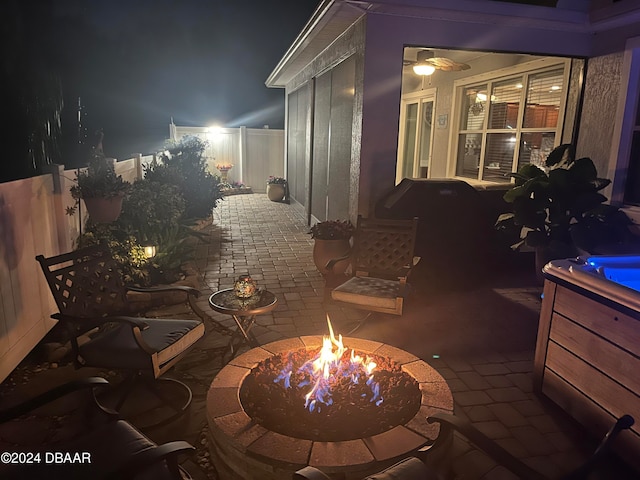 patio at twilight featuring an outdoor fire pit and a fenced backyard