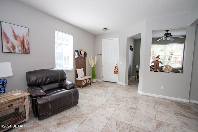 sitting room featuring ceiling fan and plenty of natural light