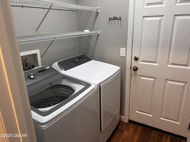 clothes washing area with dark wood-style floors, laundry area, and washing machine and clothes dryer