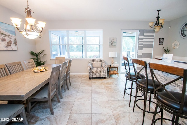 dining area featuring baseboards, light tile patterned flooring, and an inviting chandelier