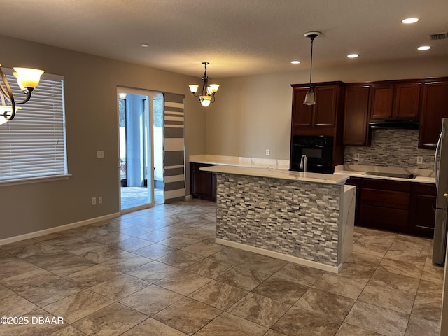 kitchen with black appliances, decorative backsplash, light countertops, and a notable chandelier