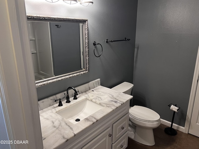 bathroom featuring toilet, tile patterned flooring, baseboards, and vanity