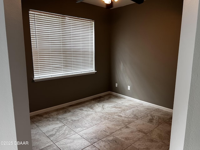 spare room featuring a ceiling fan, baseboards, and a wealth of natural light