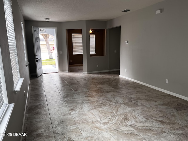 entryway featuring a textured ceiling, visible vents, and baseboards