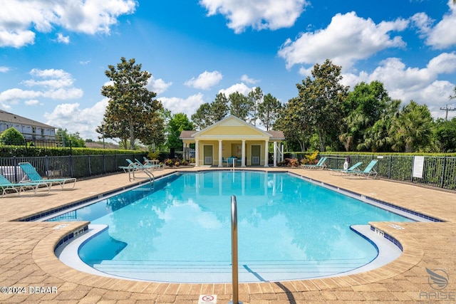 community pool featuring a patio and fence