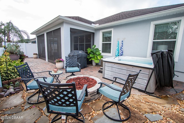 view of patio / terrace with a sunroom, fence, a hot tub, and area for grilling