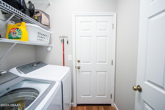 washroom featuring dark wood-style floors, laundry area, and washer and clothes dryer