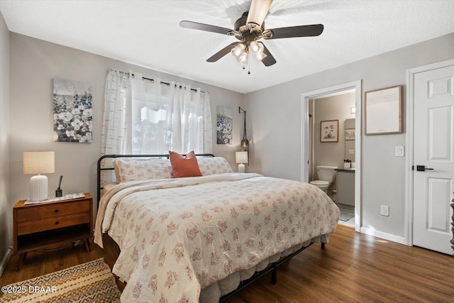 bedroom featuring connected bathroom, dark wood-type flooring, and ceiling fan