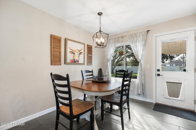 dining space featuring heating unit, a notable chandelier, and dark tile patterned floors