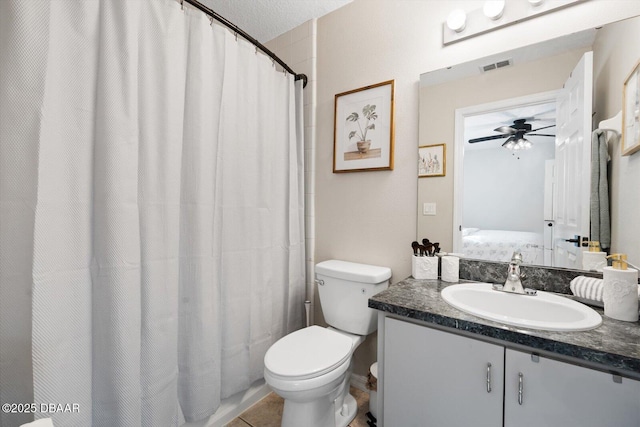 bathroom featuring walk in shower, toilet, vanity, ceiling fan, and tile patterned flooring