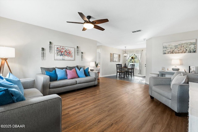 living room featuring ceiling fan and dark hardwood / wood-style flooring