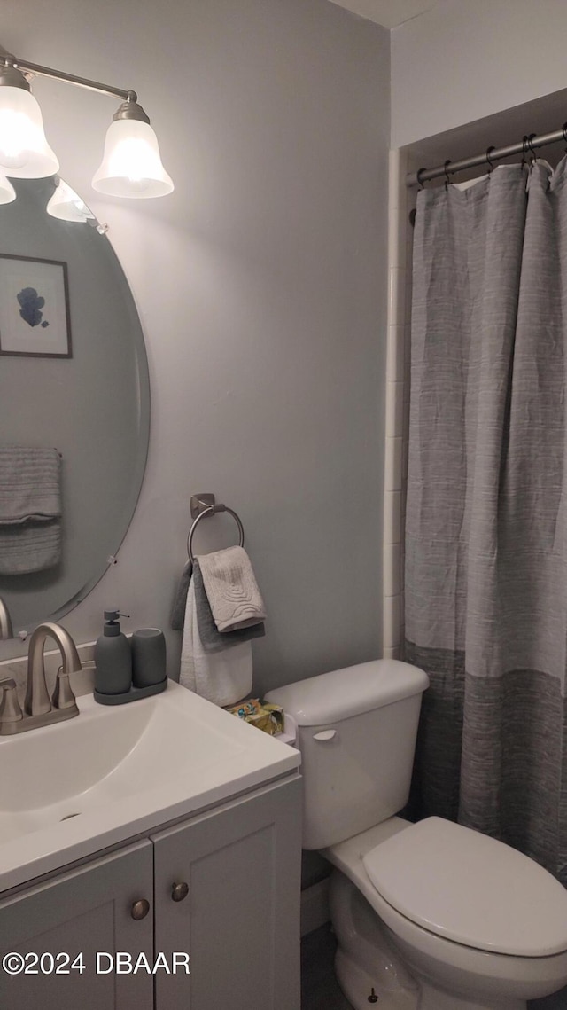 bathroom featuring walk in shower, vanity, and toilet