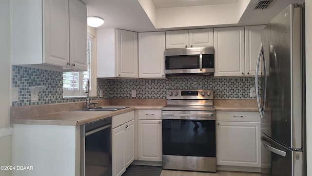 kitchen featuring white cabinetry, decorative backsplash, and stainless steel appliances