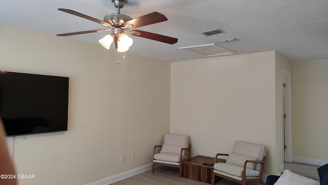 sitting room with light wood-type flooring and ceiling fan