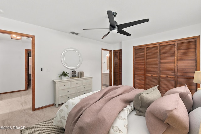 156 S Woodbridge Cir, Daytona Beach, FL 32119 - bedroom with baseboards, ceiling fan, ensuite bath, and light marble finish flooring