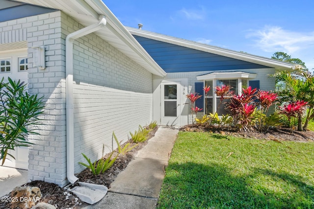 156 S Woodbridge Cir, Daytona Beach, FL 32119 - doorway to property featuring a lawn and brick siding