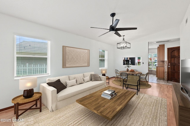 156 S Woodbridge Cir, Daytona Beach, FL 32119 - living room with light wood-style floors, a ceiling fan, vaulted ceiling, and a chandelier