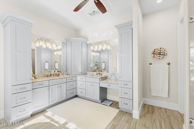 full bath featuring visible vents, baseboards, ceiling fan with notable chandelier, wood finished floors, and vanity