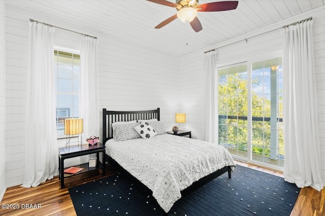 bedroom featuring multiple windows, wood ceiling, ceiling fan, and wood finished floors