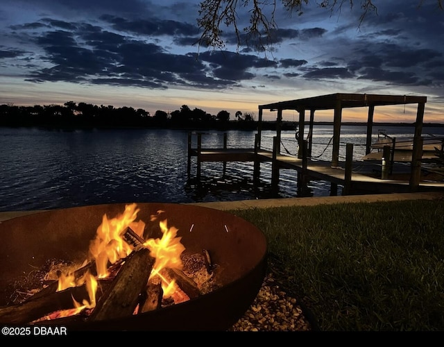 view of dock featuring an outdoor fire pit and a water view