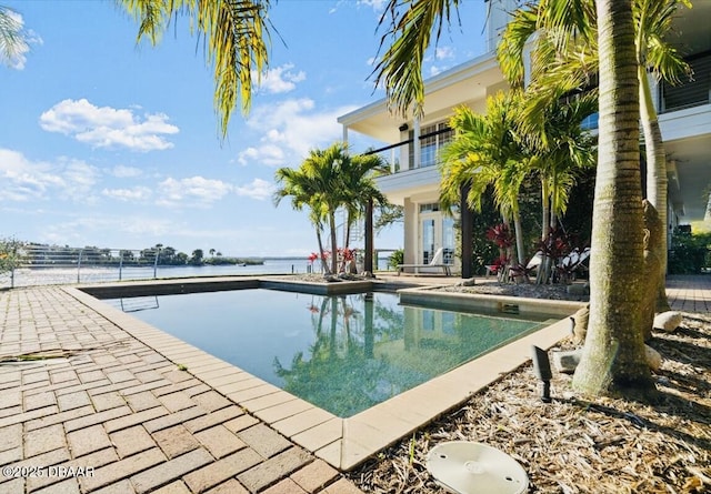 pool featuring a patio and a water view