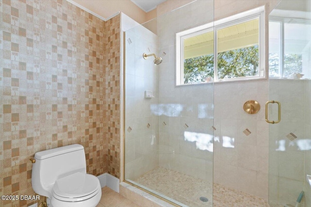 bathroom with a shower stall, toilet, and tile patterned floors