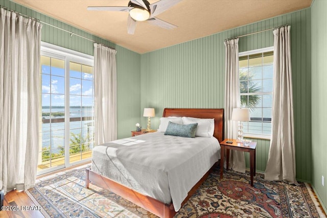 3212 John Anderson Dr, Ormond Beach, FL 32176 - bedroom featuring a ceiling fan, wood finished floors, and a water view