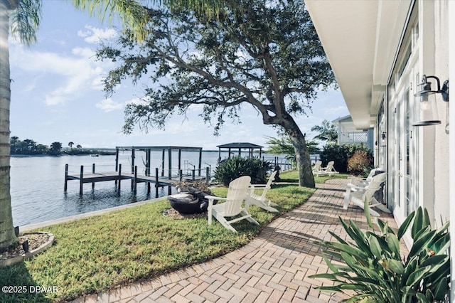 dock area with a lawn and a water view