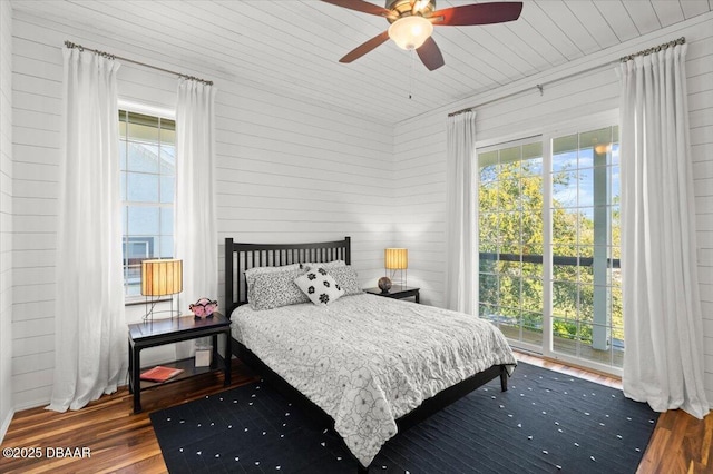 3212 John Anderson Dr, Ormond Beach, FL 32176 - bedroom with wood finished floors, multiple windows, wood walls, and a ceiling fan