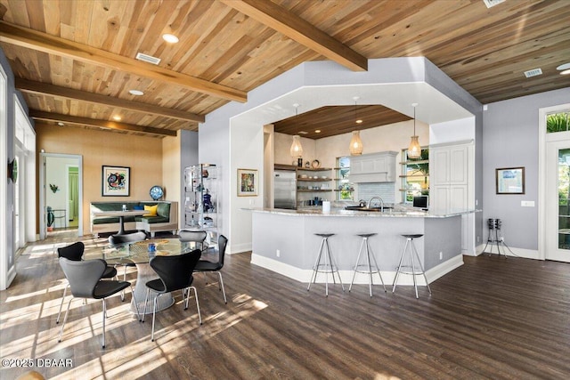 3212 John Anderson Dr, Ormond Beach, FL 32176 - interior space featuring stainless steel built in fridge, dark wood-type flooring, open shelves, decorative backsplash, and wood ceiling