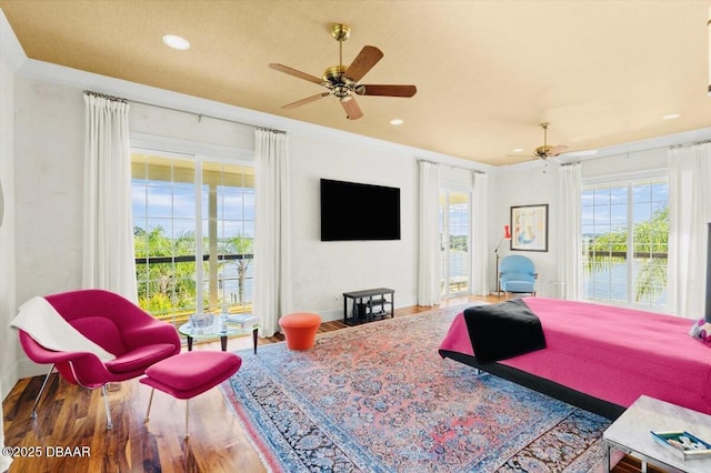 bedroom featuring wood finished floors, baseboards, recessed lighting, ceiling fan, and crown molding