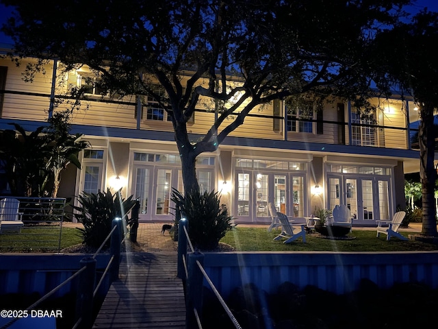3212 John Anderson Dr, Ormond Beach, FL 32176 - back of house at twilight with french doors and a yard